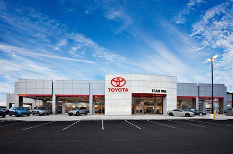 A toyota dealership with cars parked in front of it.
