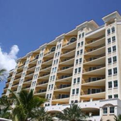 A large white building with palm trees in front of it.